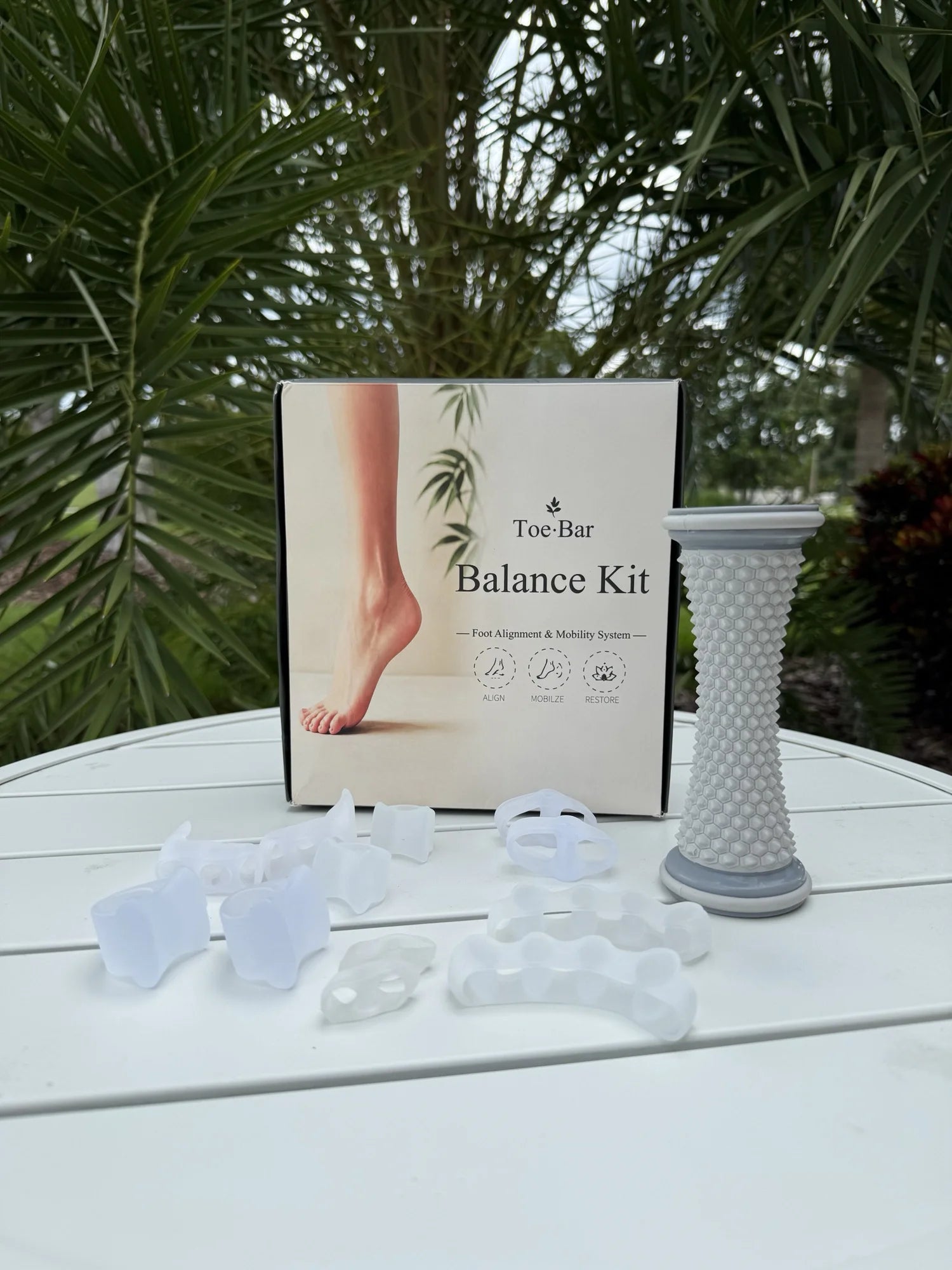 Toe-Bar Balance Kit box with silicone toe correctors and foot roller spread out on white table